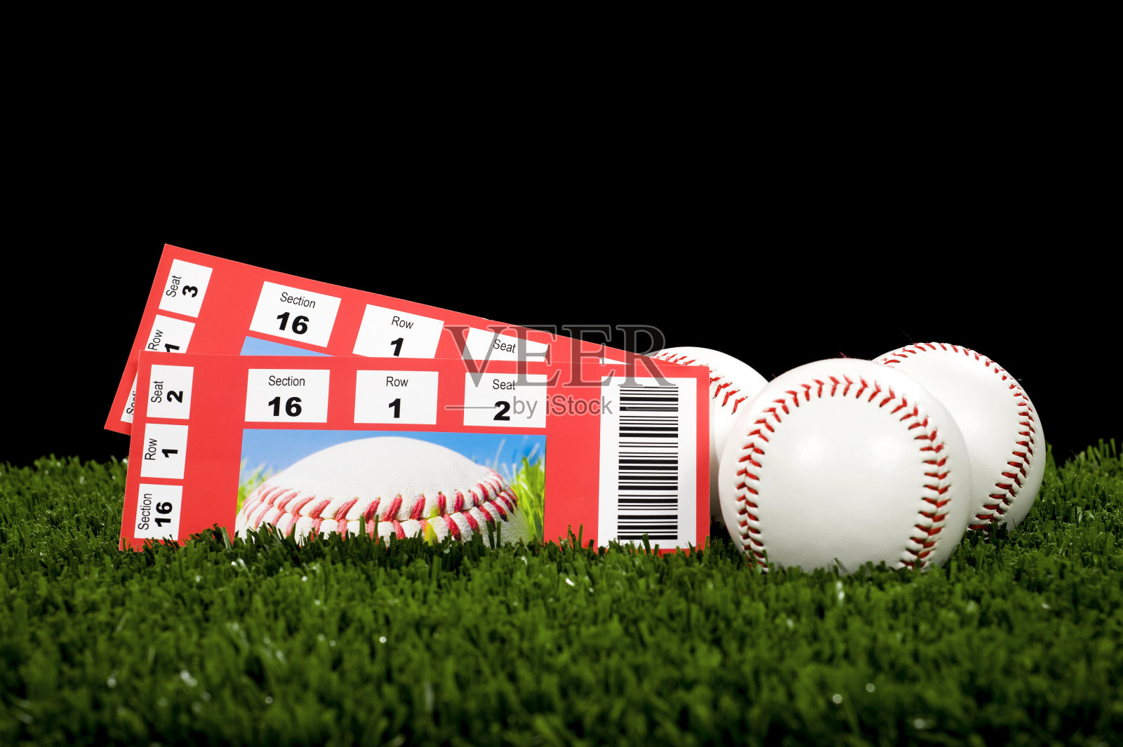 两张棒球比赛的门票，在草地上放球照片摄影图片