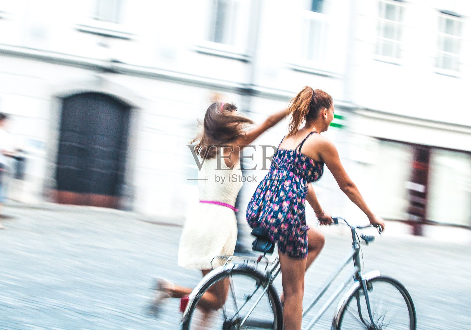 青少年朋友在城市里玩得很开心，一起骑自行车照片摄影图片