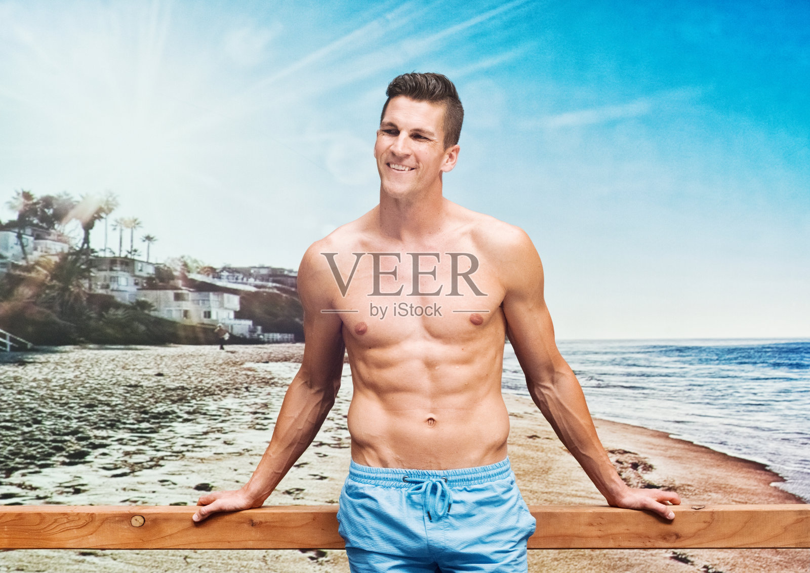 一个肌肉发达的男人斜靠在海滩的长椅上照片摄影图片