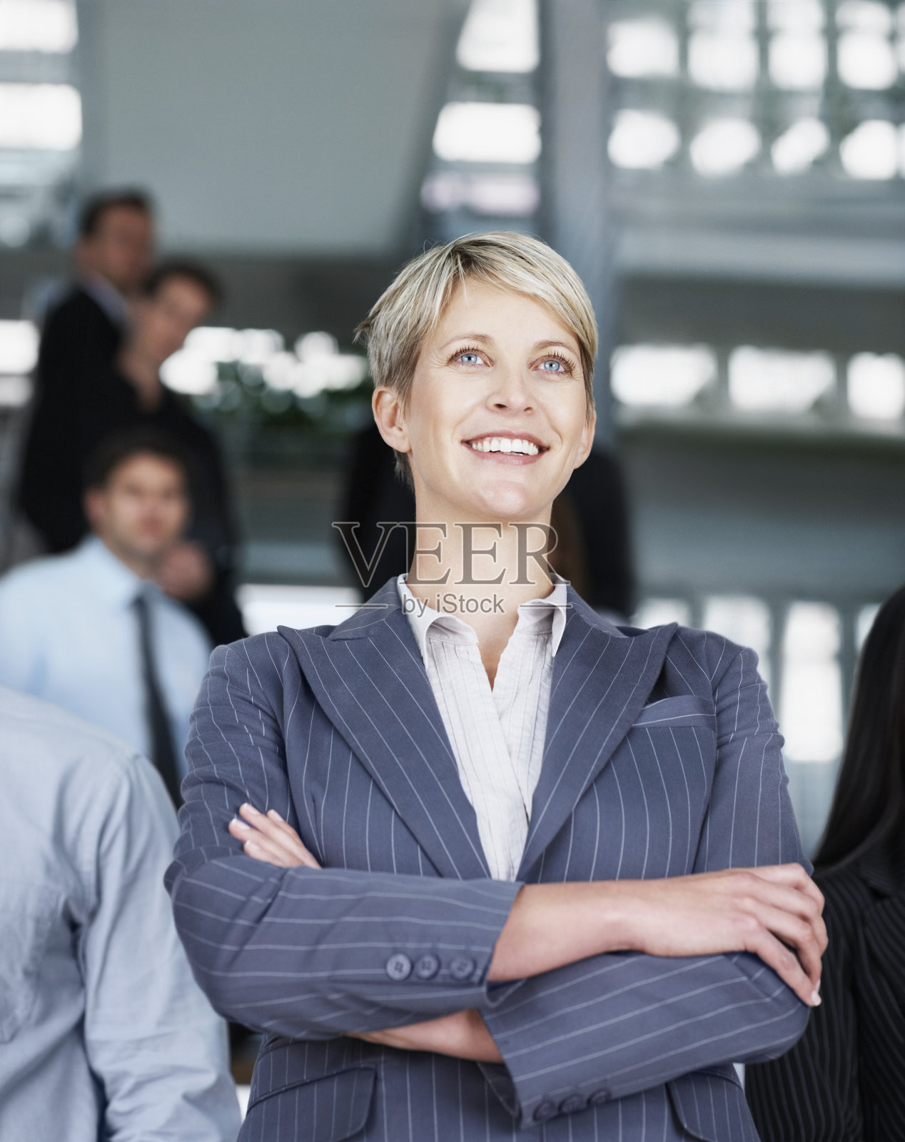 女商人微笑着，同事们在后面照片摄影图片