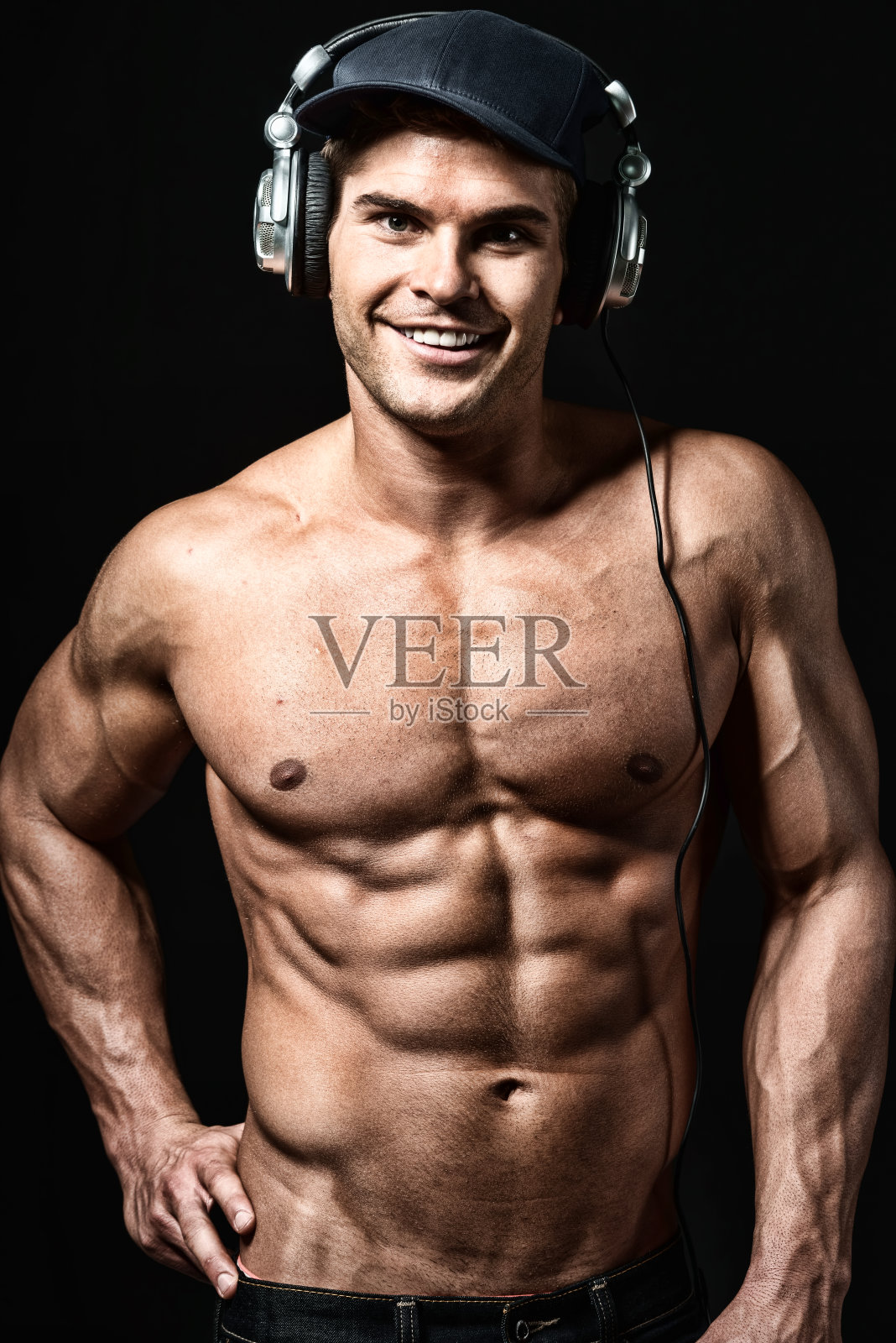 肌肉发达的男人微笑着听音乐照片摄影图片