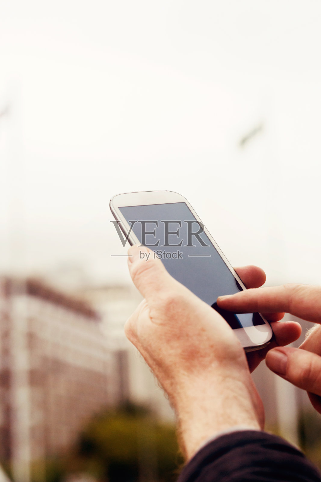 男性在办公大楼外使用智能手机照片摄影图片