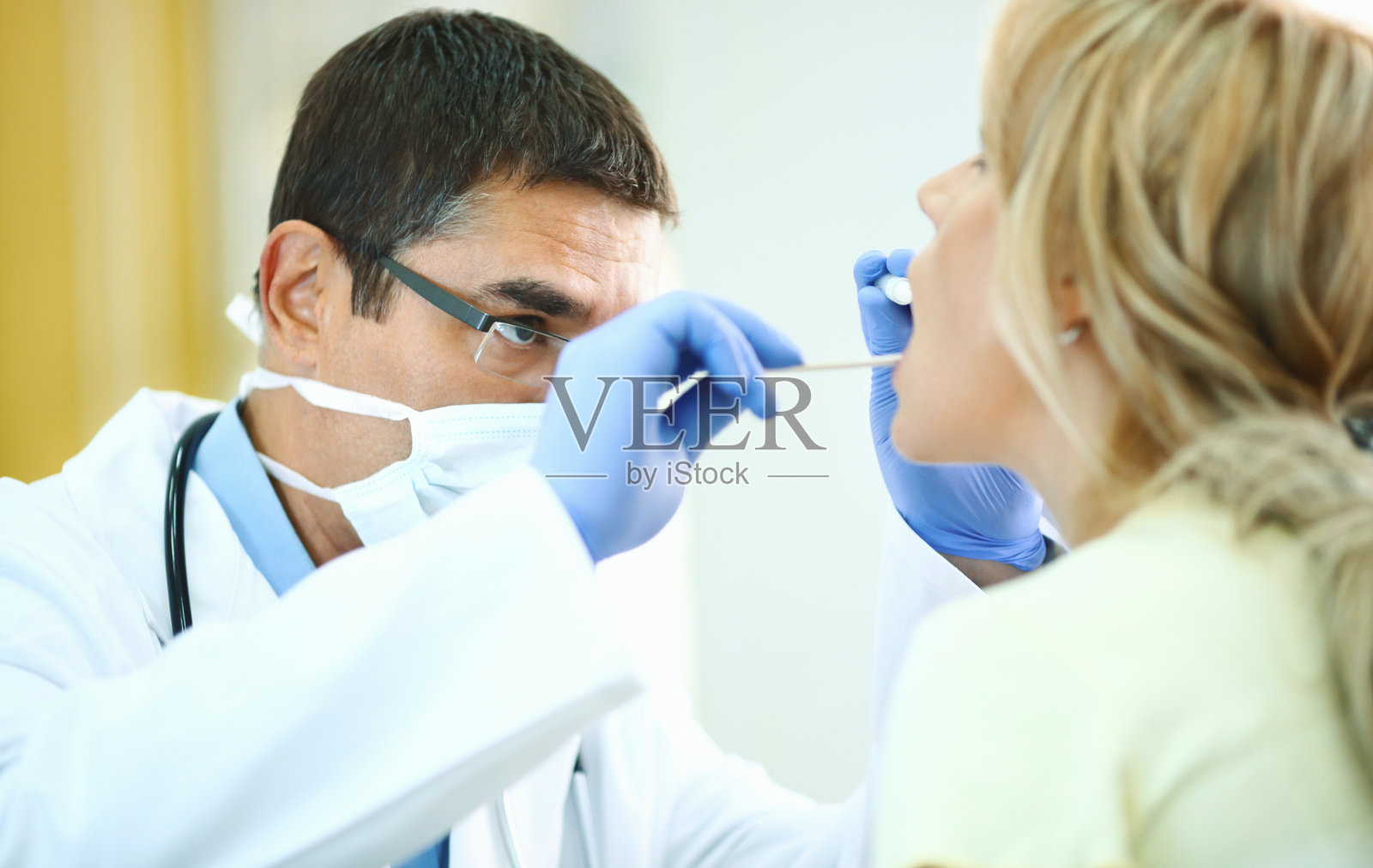 医生检查病人的喉咙。照片摄影图片