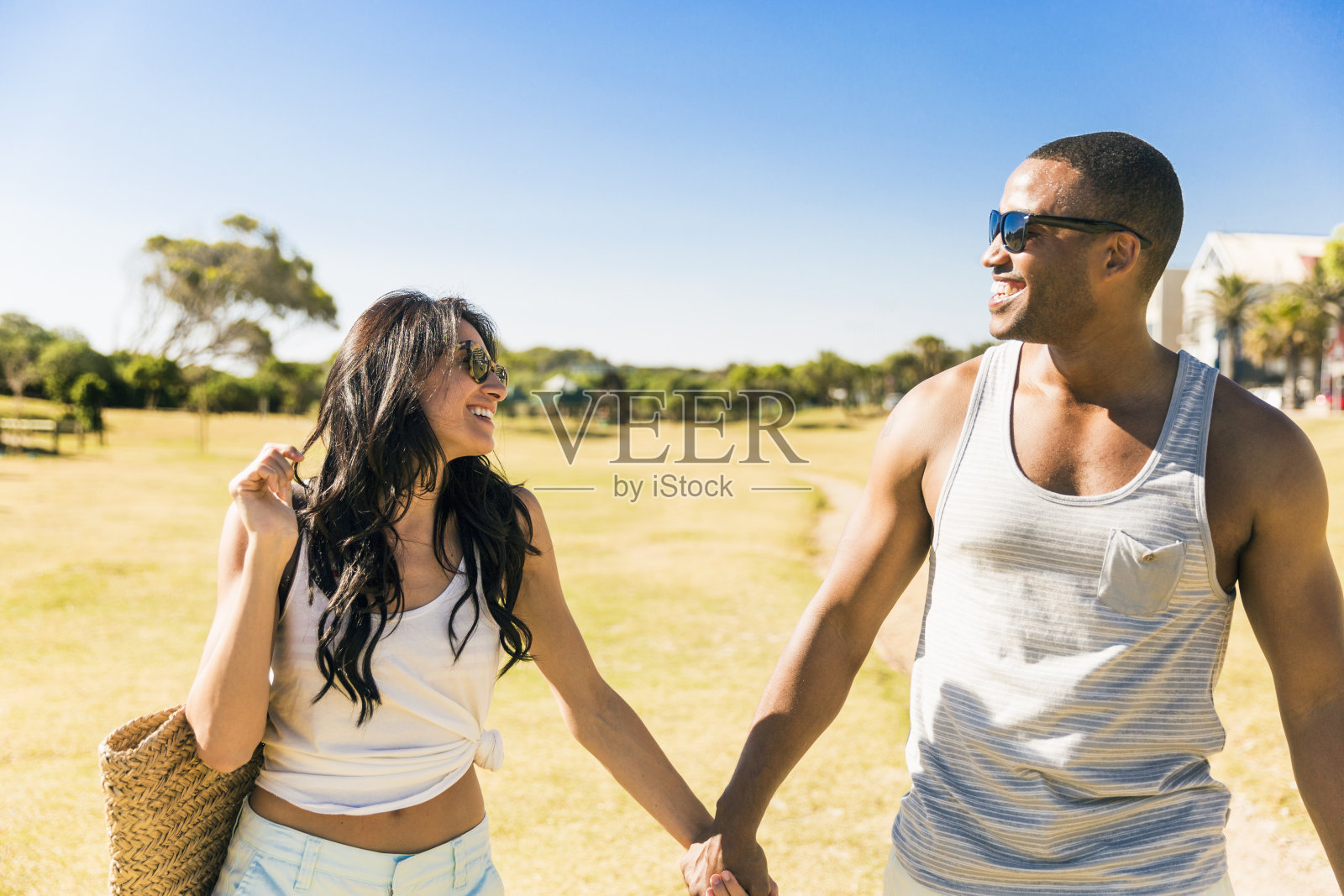 幸福的一对手牵着手在海滩上散步照片摄影图片