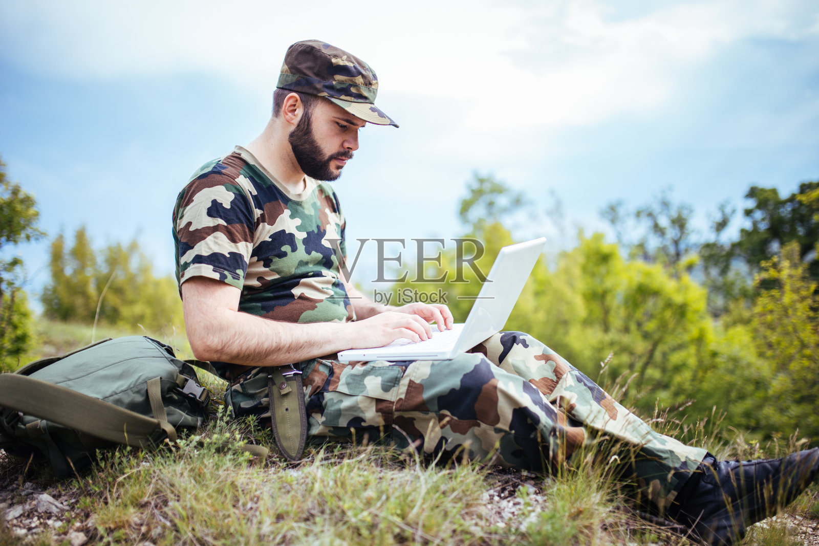 年轻士兵在户外使用笔记本电脑照片摄影图片