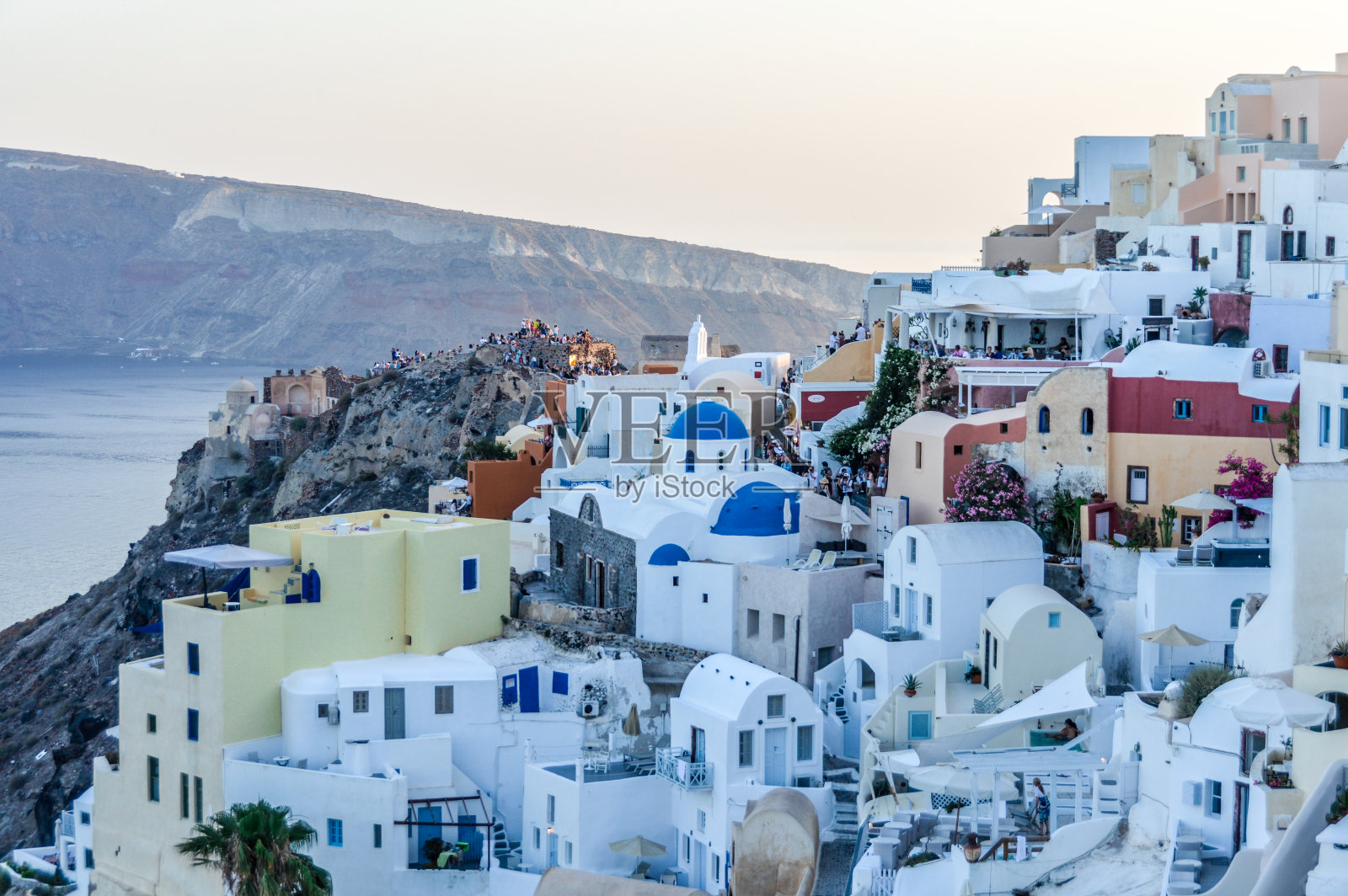 日落时分，希腊圣托里尼岛的伊亚镇照片摄影图片