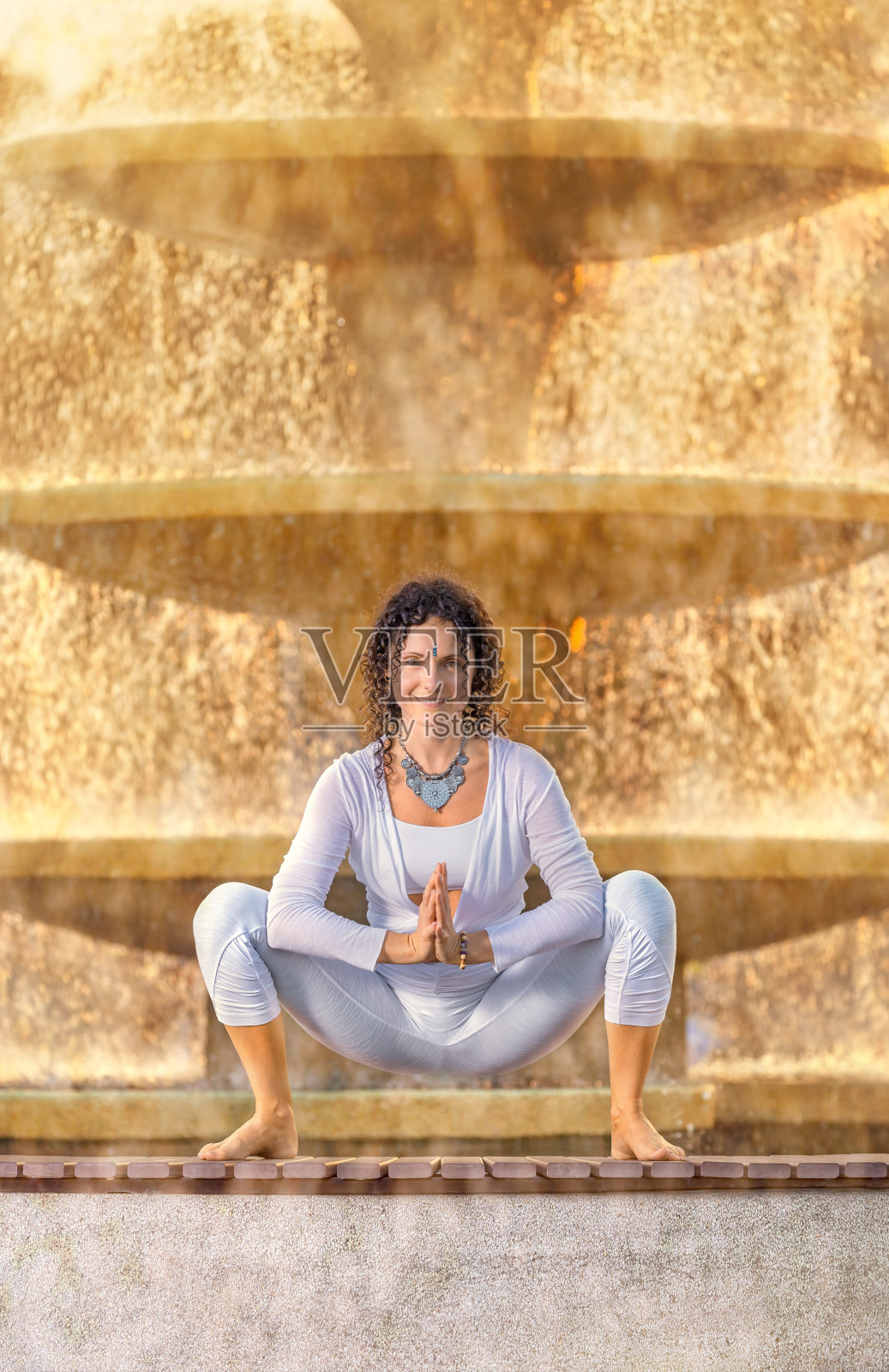 瑜伽姿势的女人在户外锻炼喷泉照片摄影图片