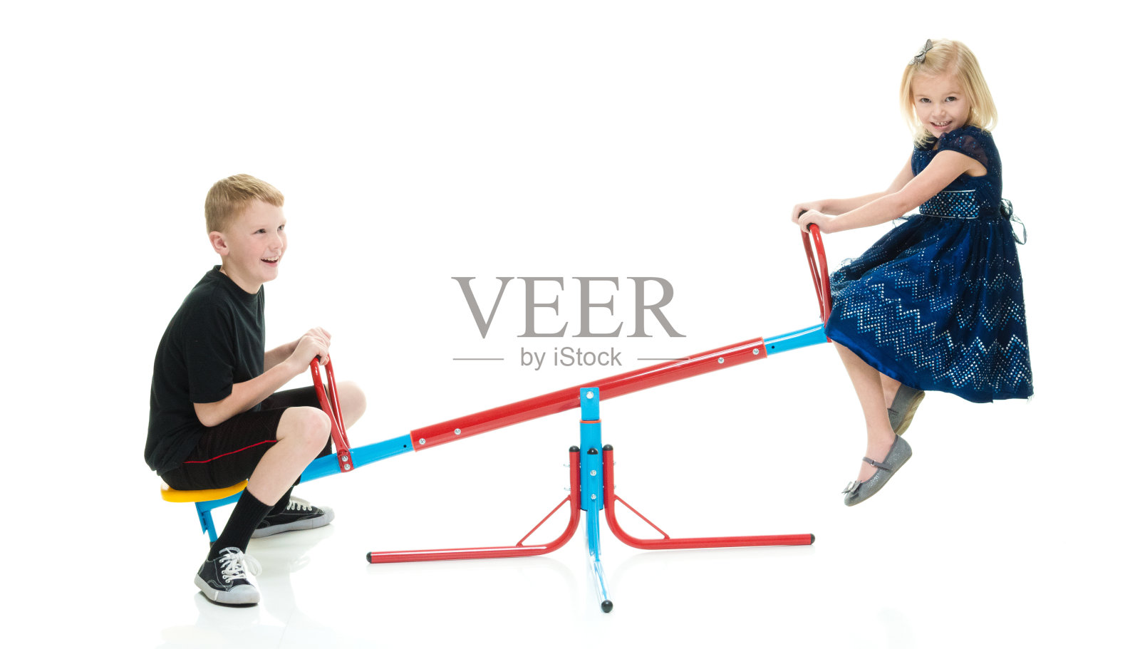 微笑的弟弟和妹妹玩跷跷板照片摄影图片