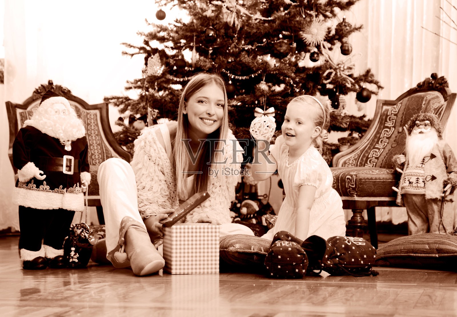 妈妈和女儿坐在圣诞树前照片摄影图片