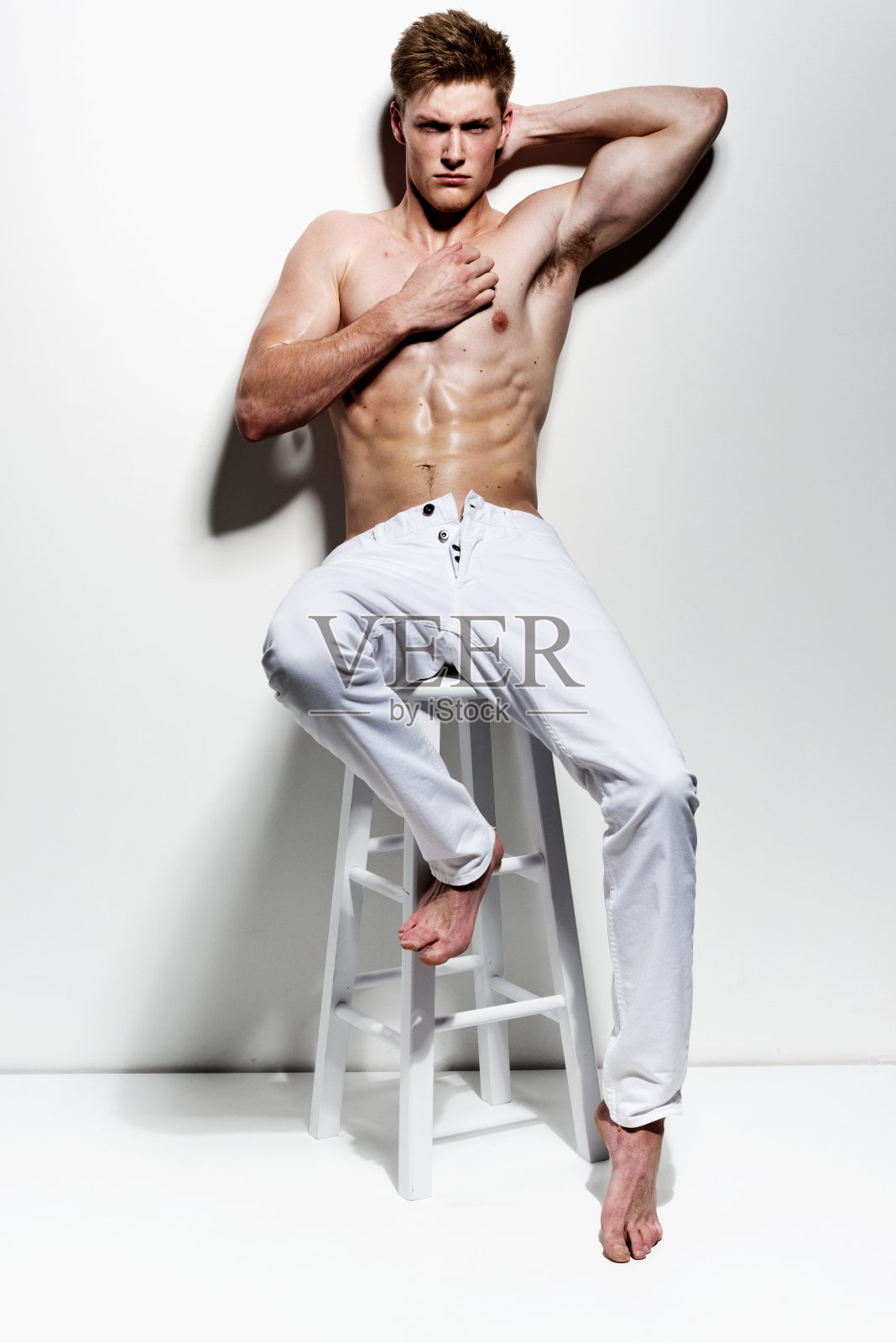 坐在凳子上的肌肉男照片摄影图片