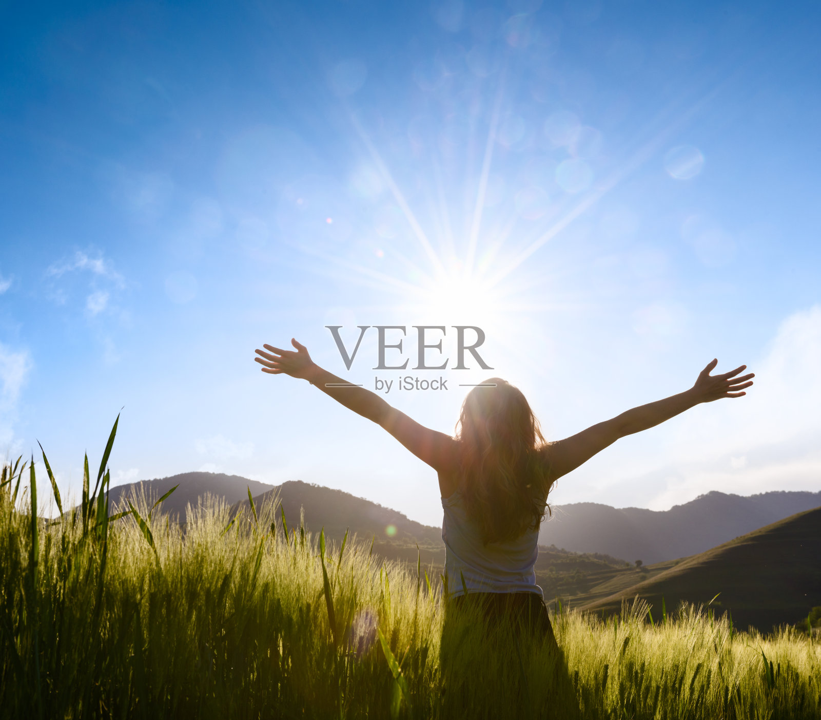 麦田里有个女人伸出双手的剪影照片摄影图片