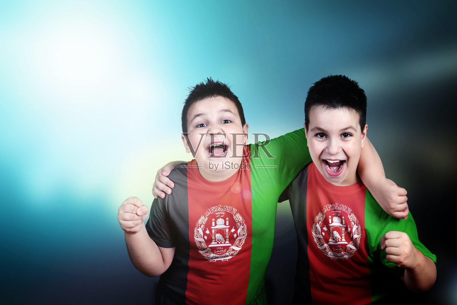两名男孩的足球迷，t恤上印着阿富汗国旗照片摄影图片