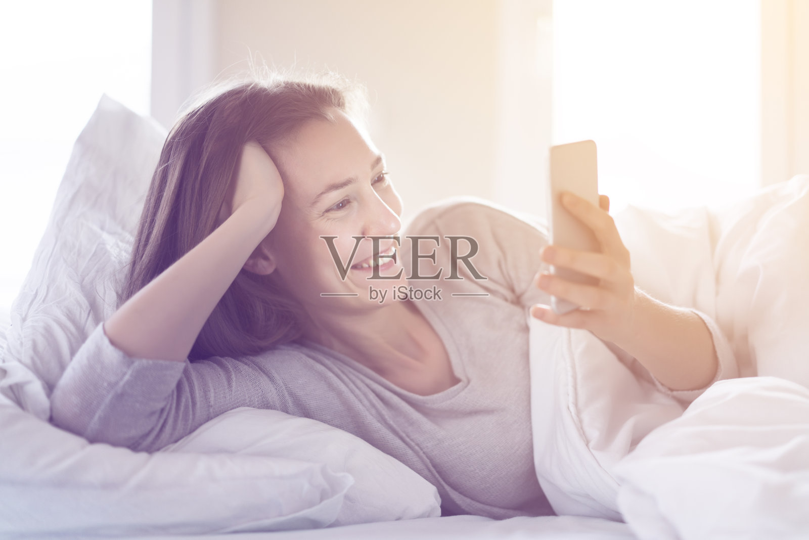 女人在床上打电话照片摄影图片