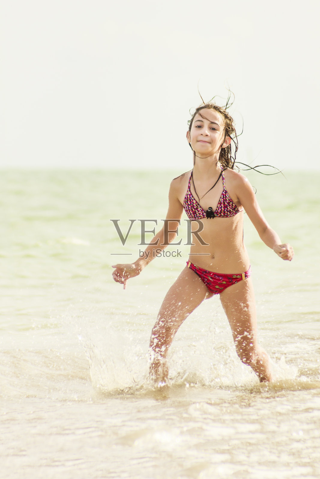 快乐的小女孩享受假期在荒芜的海滩照片摄影图片