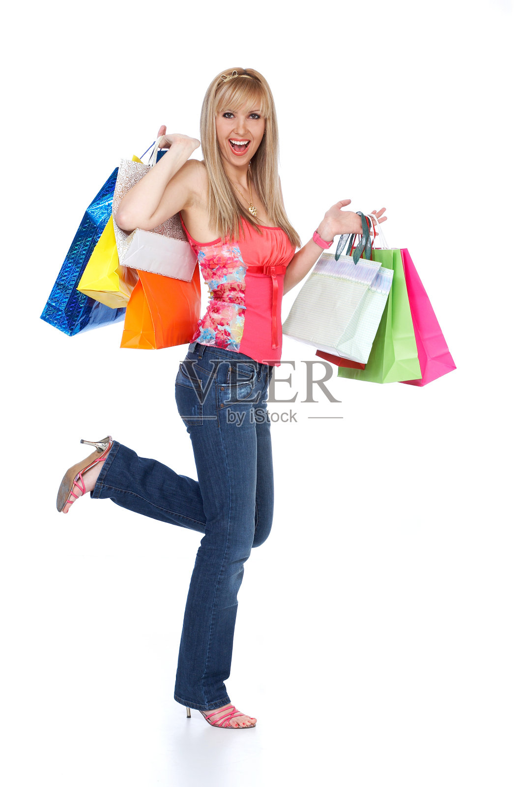 快乐的金发女孩拿着购物袋孤立在白色的背景照片摄影图片