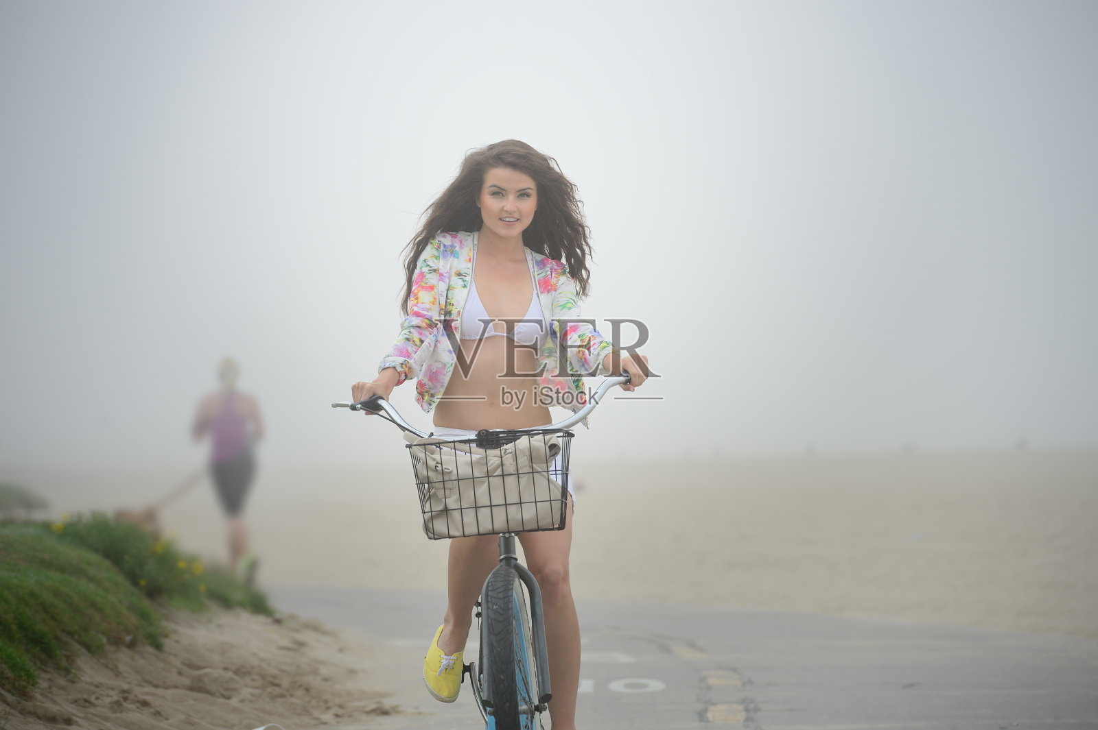 年轻女子骑着自行车，清晨有雾照片摄影图片
