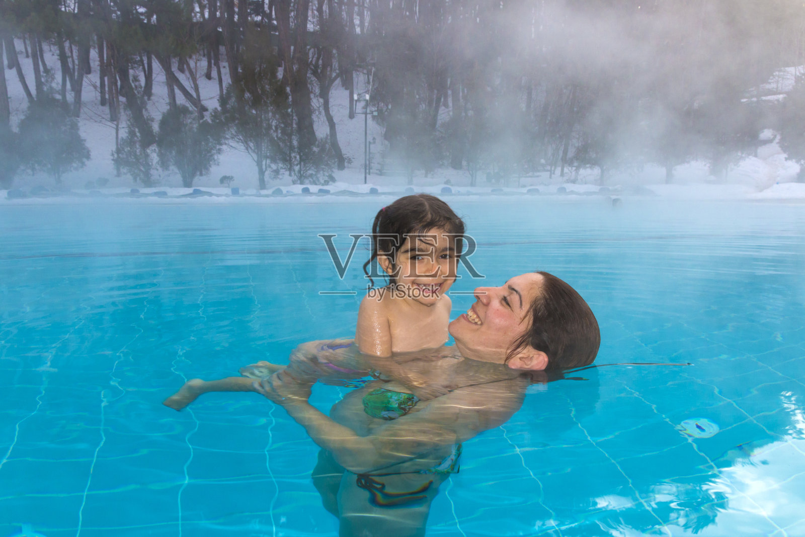 母亲和女儿在热水中放松照片摄影图片