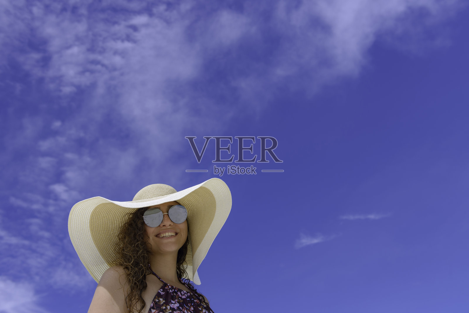 蓝天下微笑的年轻女子照片摄影图片