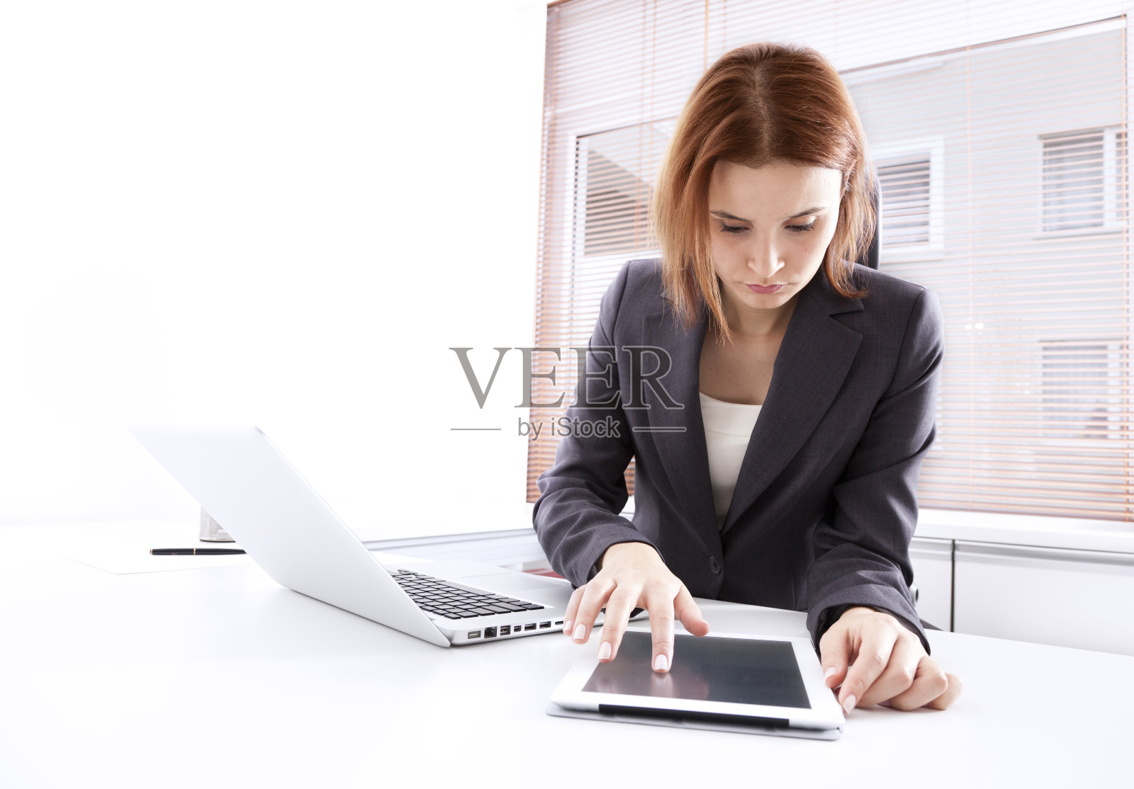 职场女性在办公室使用触屏平板电脑照片摄影图片