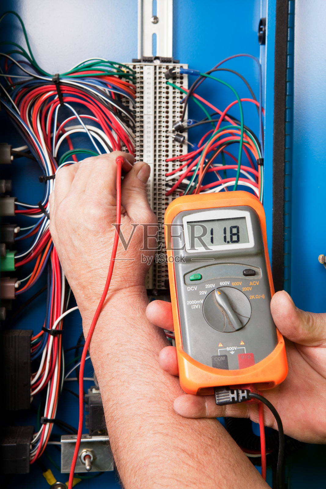 服务技术员在设备接线座上使用万用表照片摄影图片