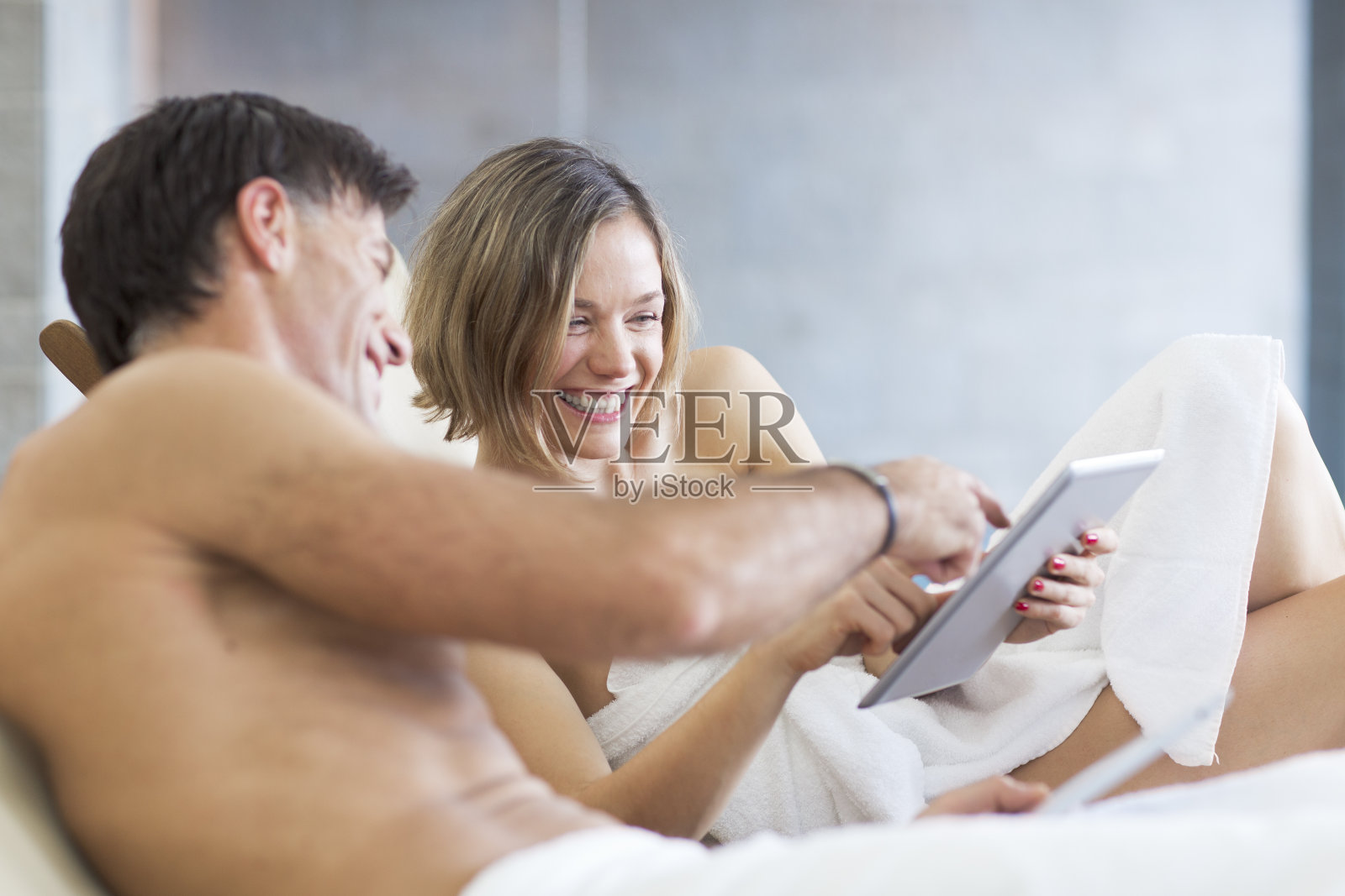 情侣们正在享受水疗和使用数码平板电脑照片摄影图片