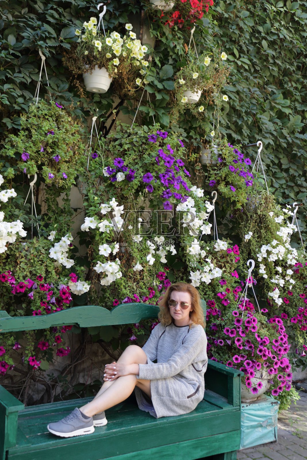 在花墙前的女人。照片摄影图片