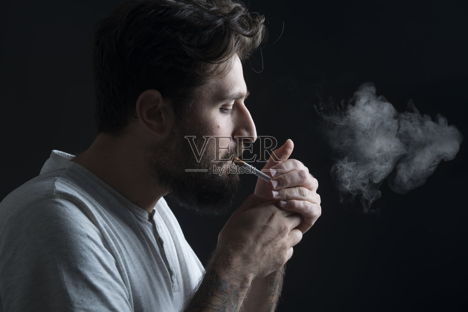 一个点燃香烟的男孩的肖像照片摄影图片