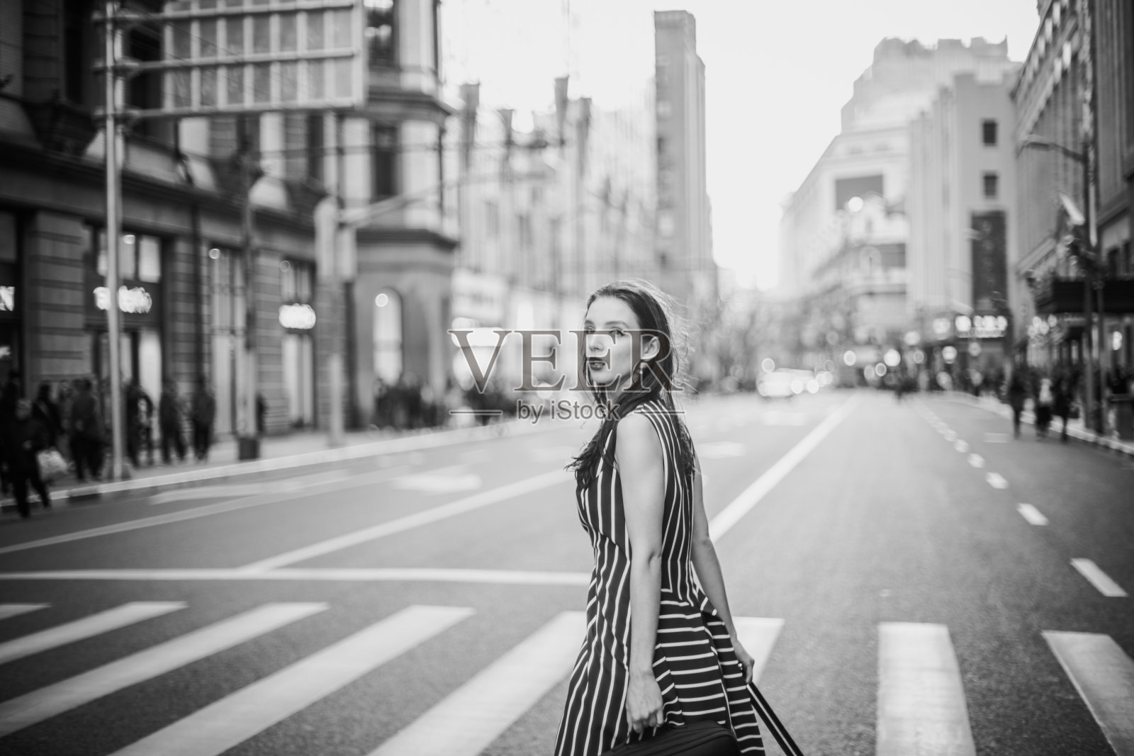 走在人行横道上的女人照片摄影图片