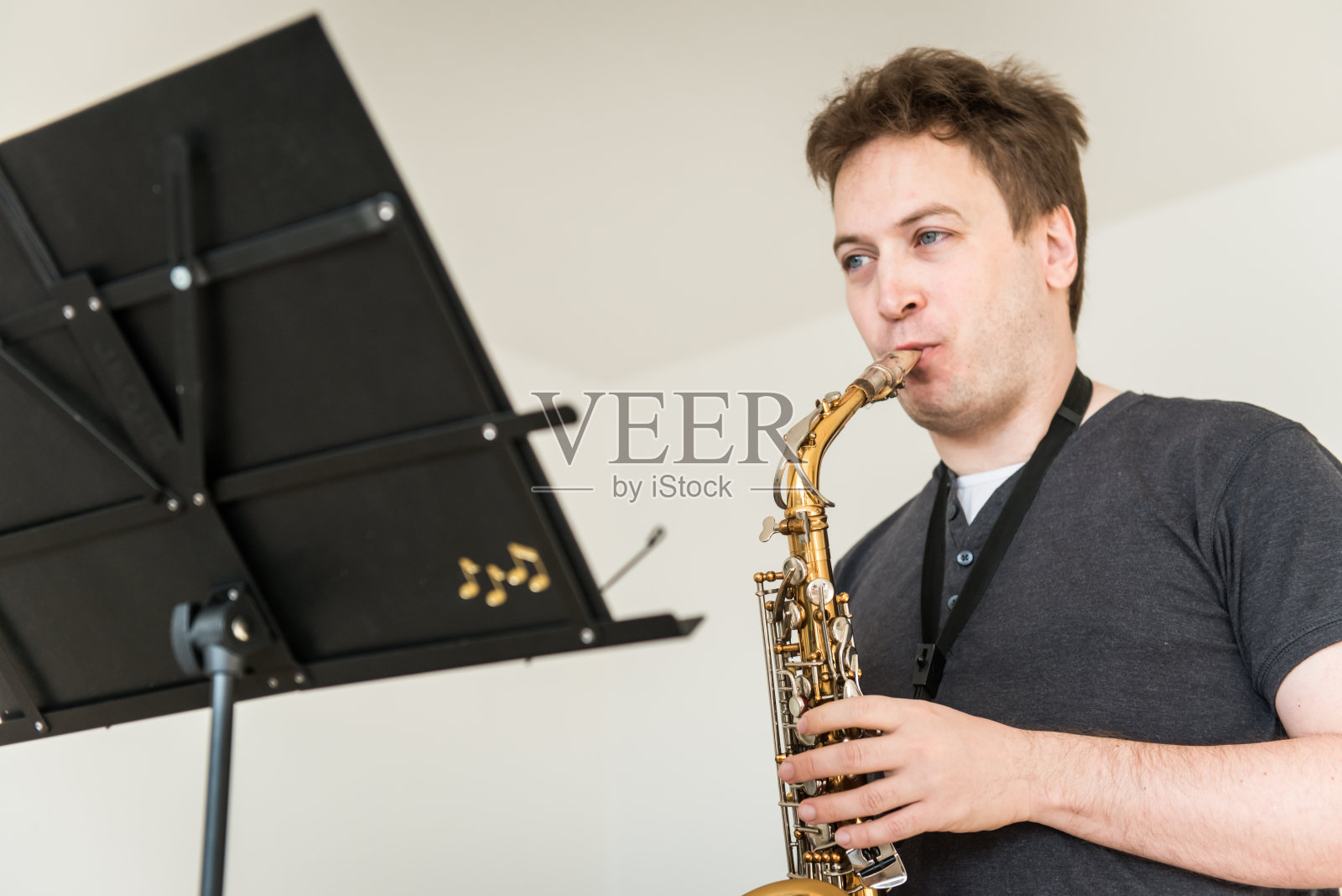 一个年轻人在家里吹萨克斯照片摄影图片