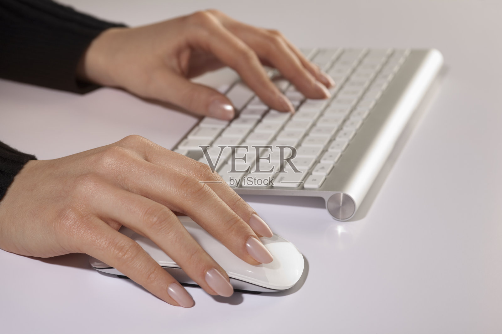 手打字与干净的白色无线电脑键盘和鼠标照片摄影图片