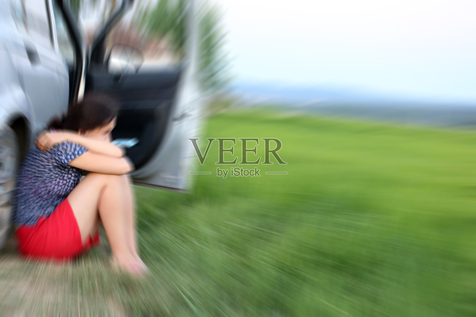 心烦意乱的女人在车外看着绿色的田野照片摄影图片