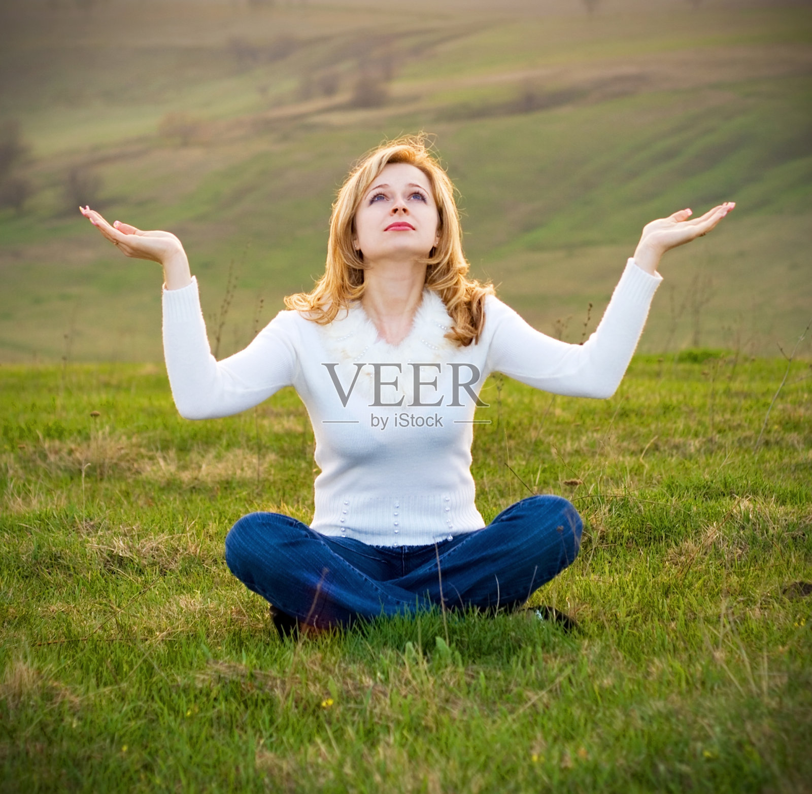 在草地上做瑜伽的女人照片摄影图片