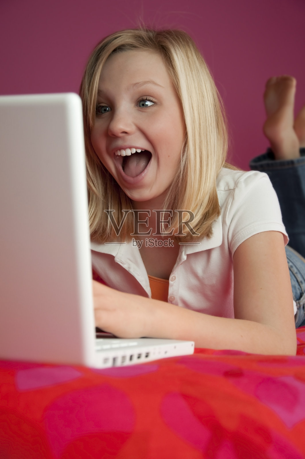 在笔记本电脑上笑的快乐少女照片摄影图片