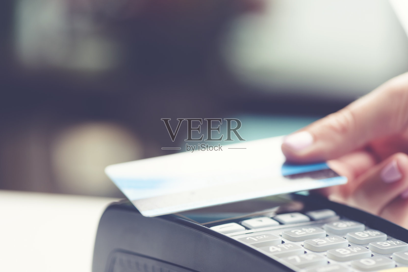 女人在刷非接触式信用卡。照片摄影图片