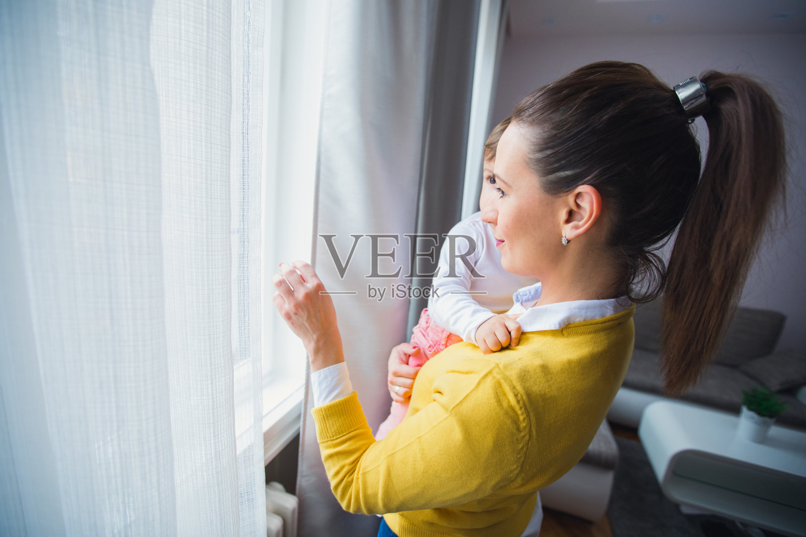 妈妈和孩子站在窗边照片摄影图片
