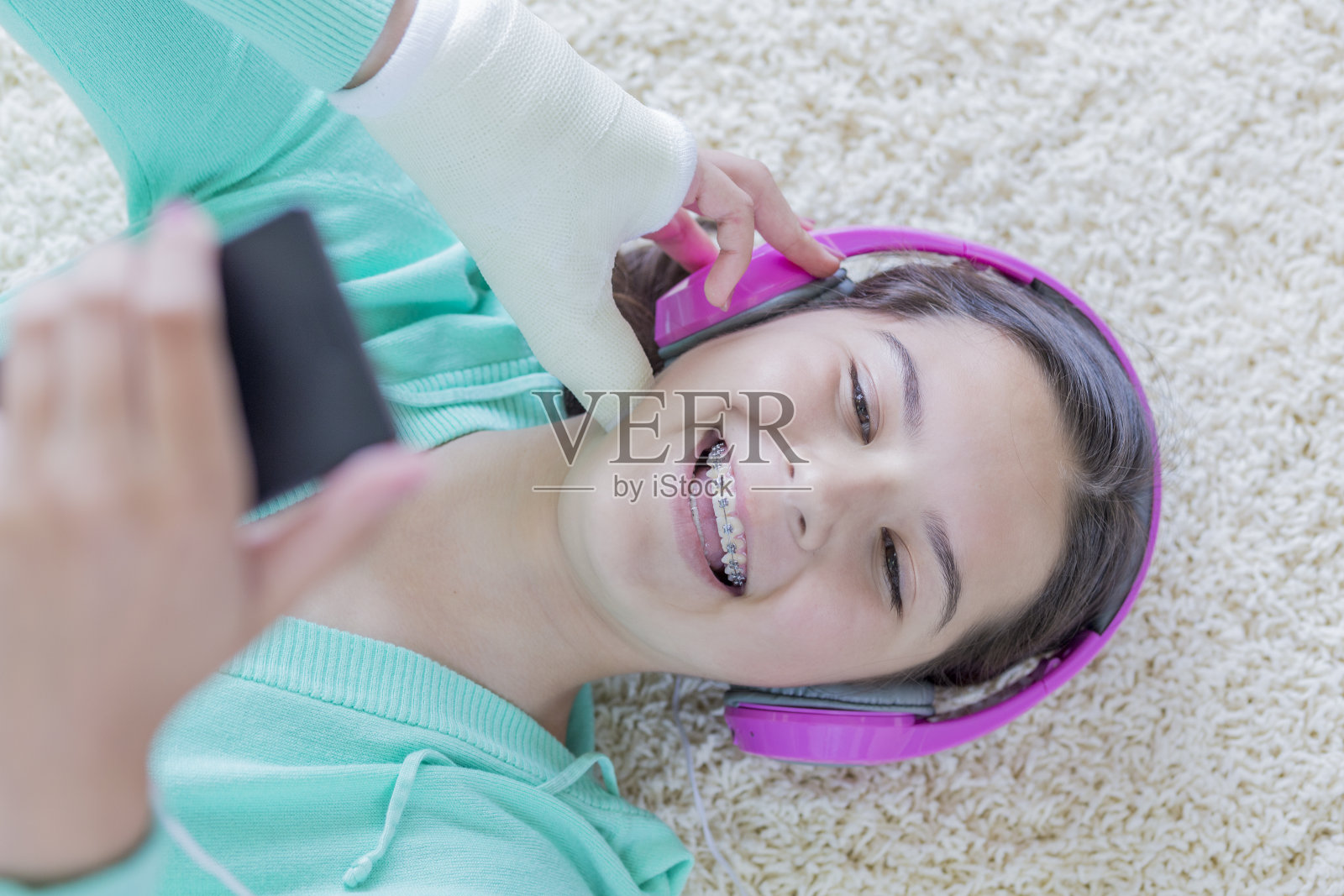 开朗的青少年戴着耳机使用智能手机照片摄影图片