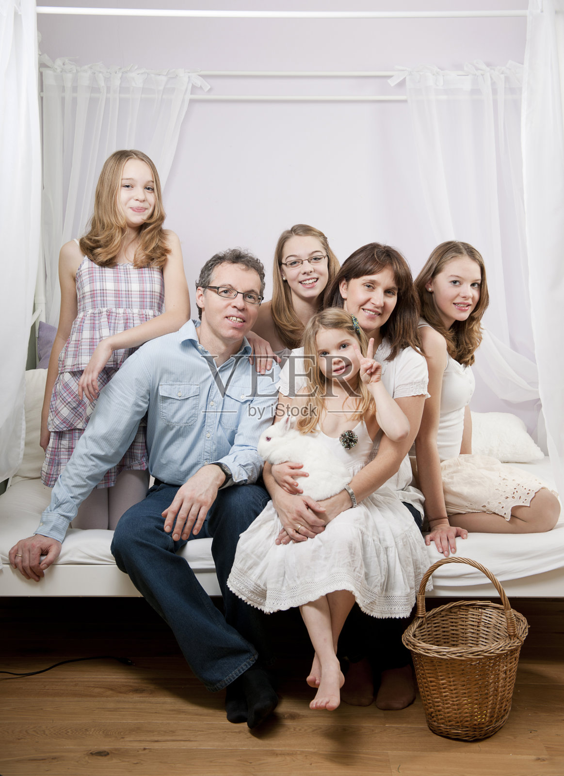 幸福的一家人坐在床上照片摄影图片