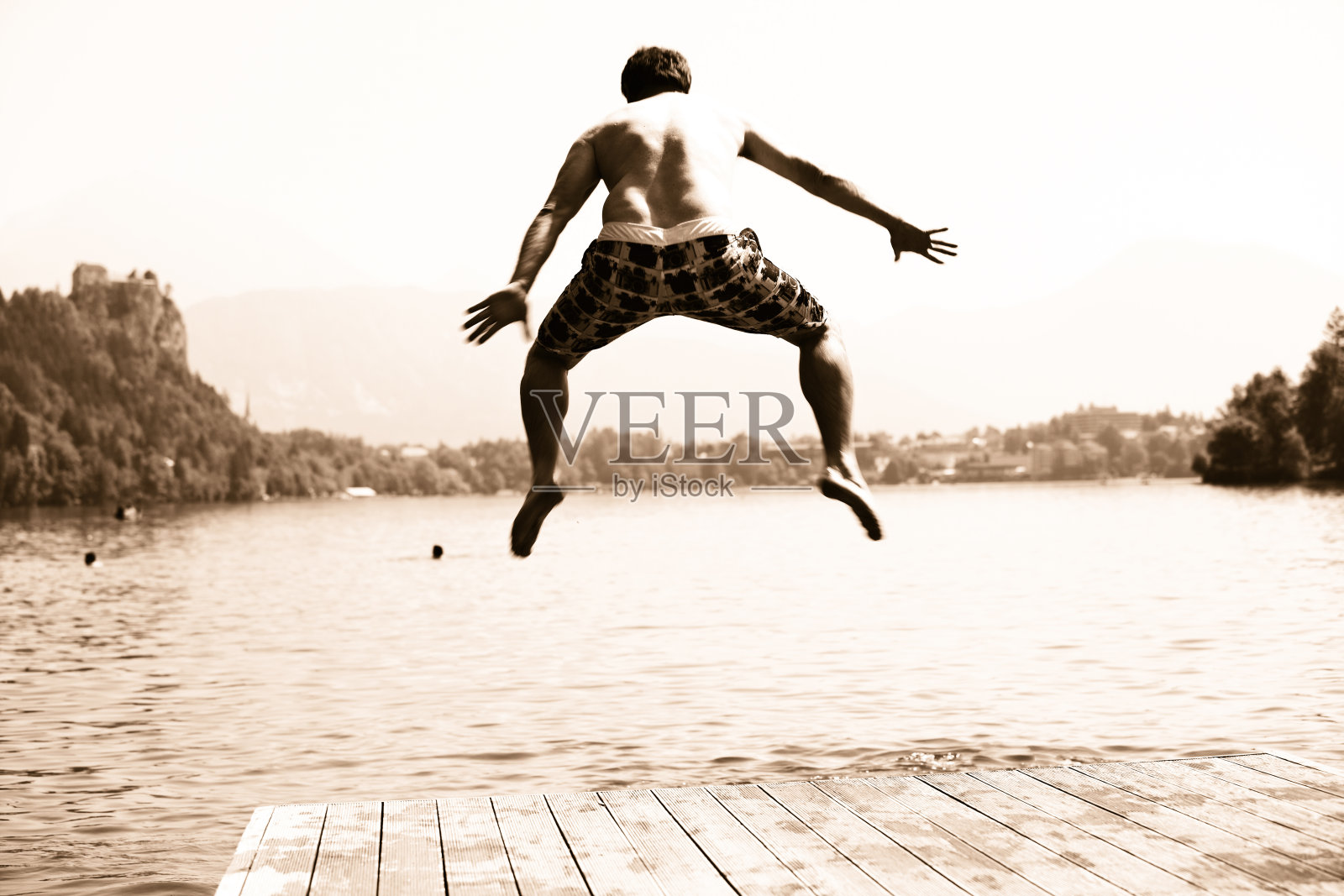 半空中有个人跳进湖里照片摄影图片