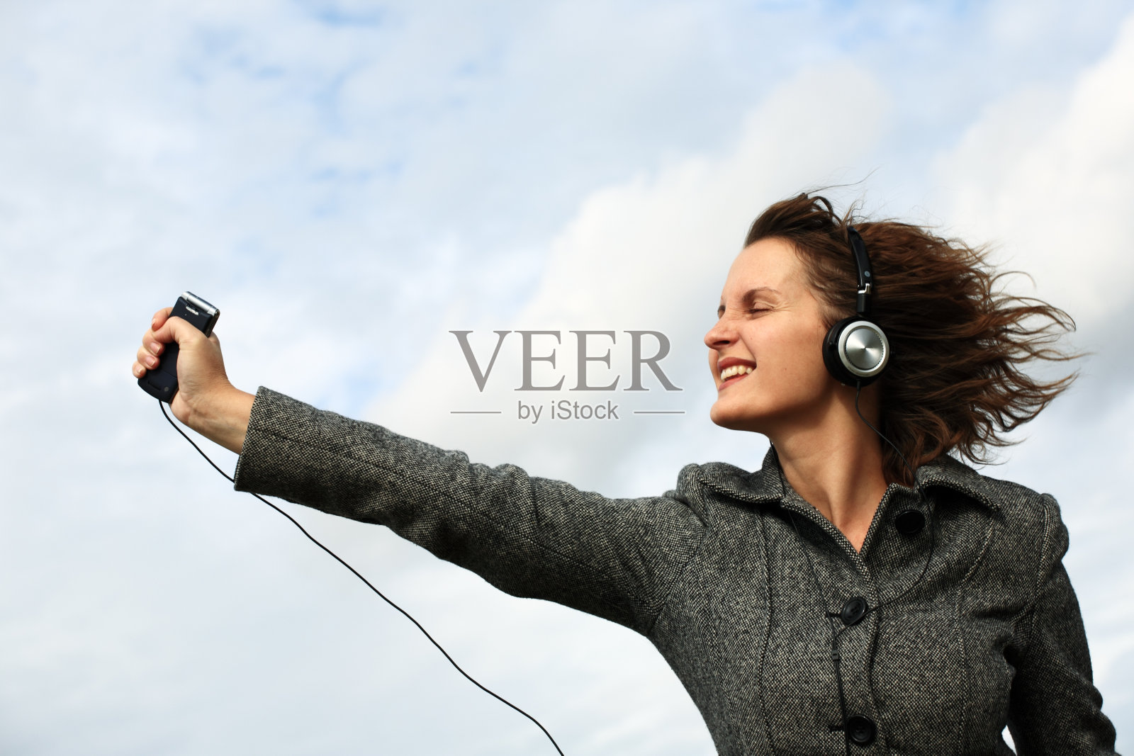 带立体声耳机和手机的中年妇女照片摄影图片