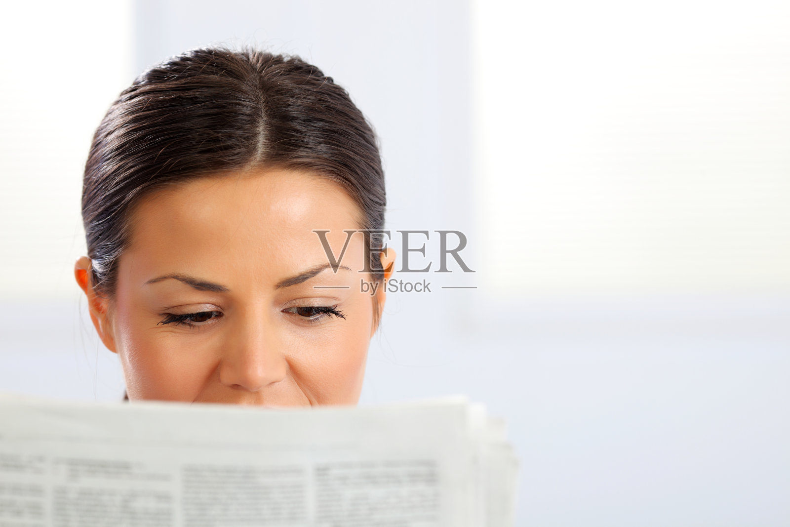 美丽的女孩在报纸上读新闻。照片摄影图片