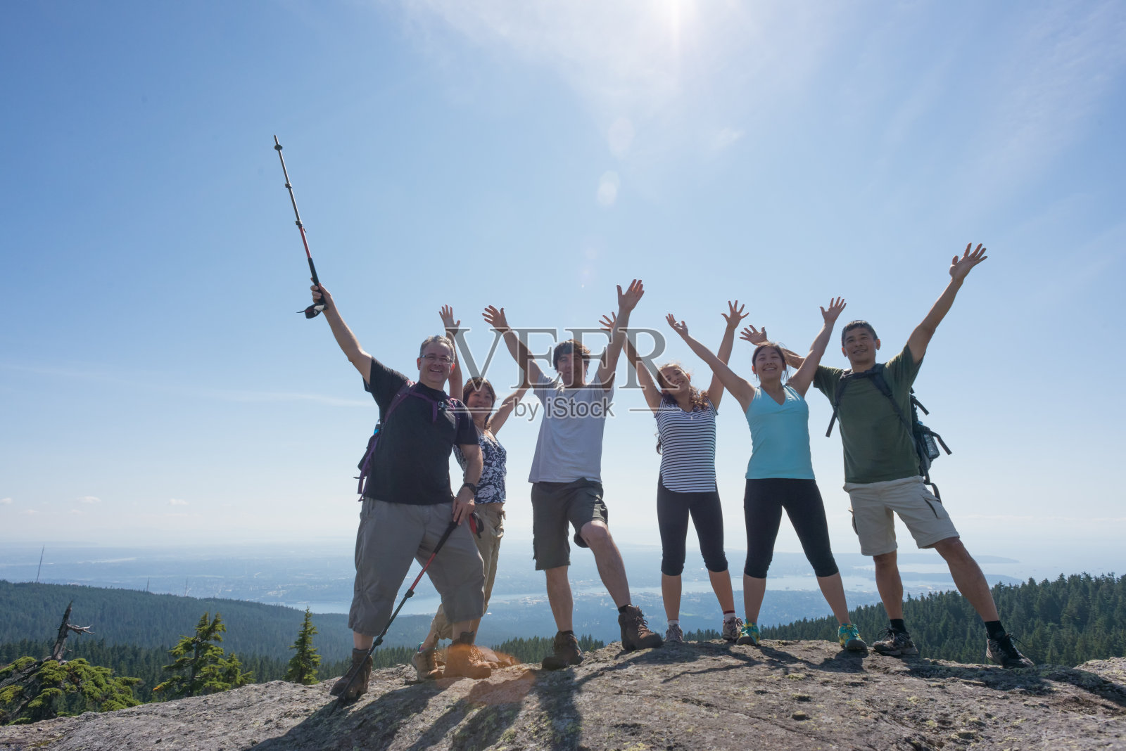 几代同堂的家人和朋友在山顶上伸开双臂庆祝照片摄影图片