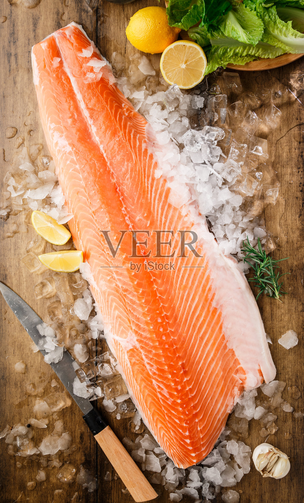 黑色的桌子上放着冰上的鲑鱼照片摄影图片