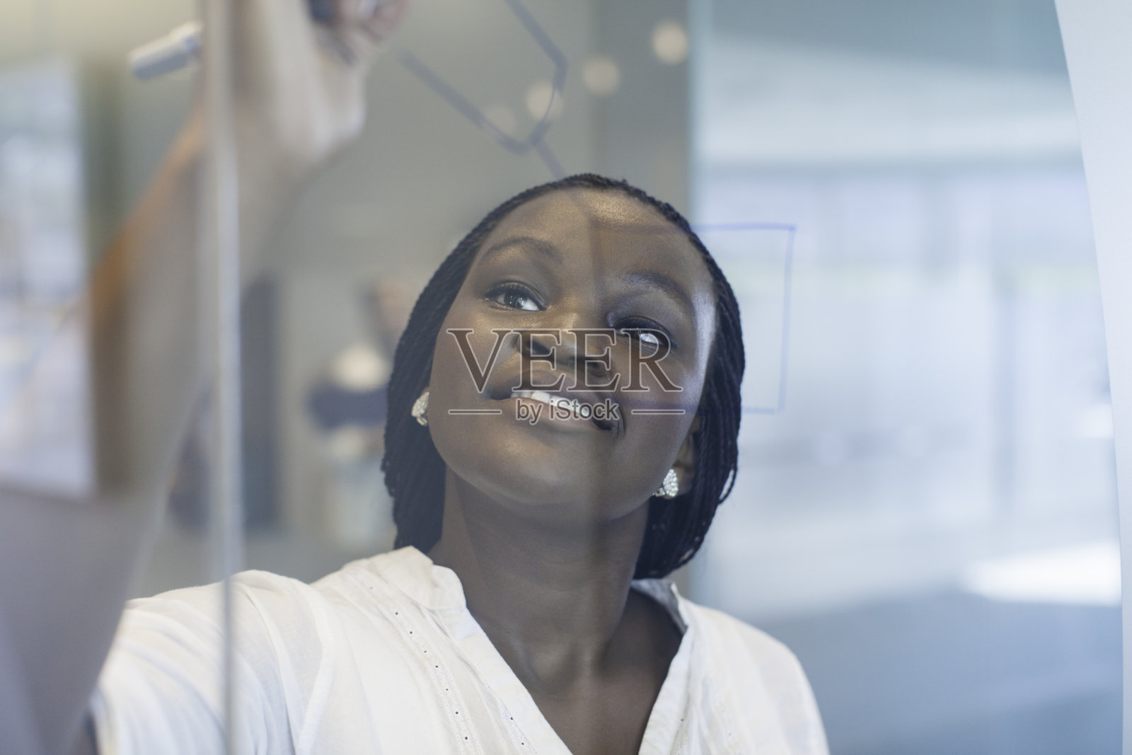 非洲女商人在透明的玻璃上描绘自己的想法。照片摄影图片