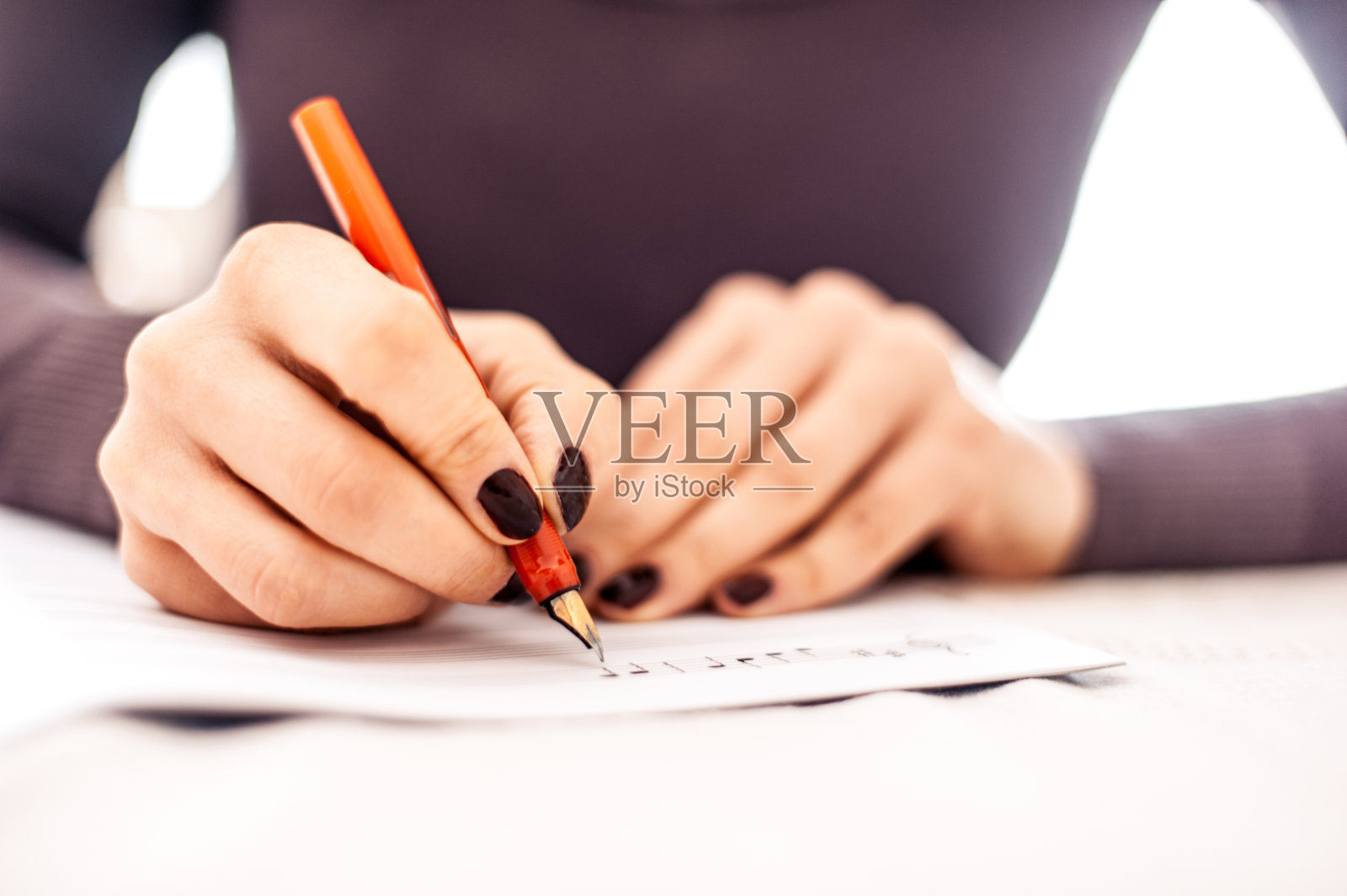 年轻的成年妇女写音符-关闭的手照片摄影图片