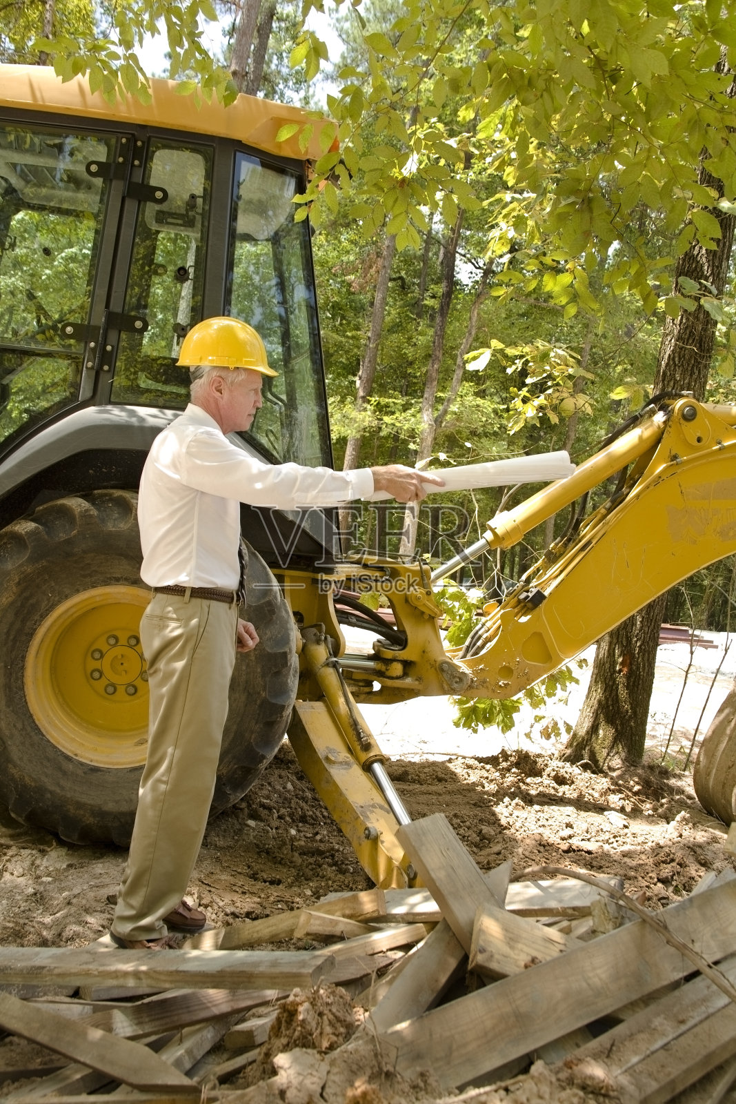 建筑师在工作，背后有蓝图和拖拉机照片摄影图片