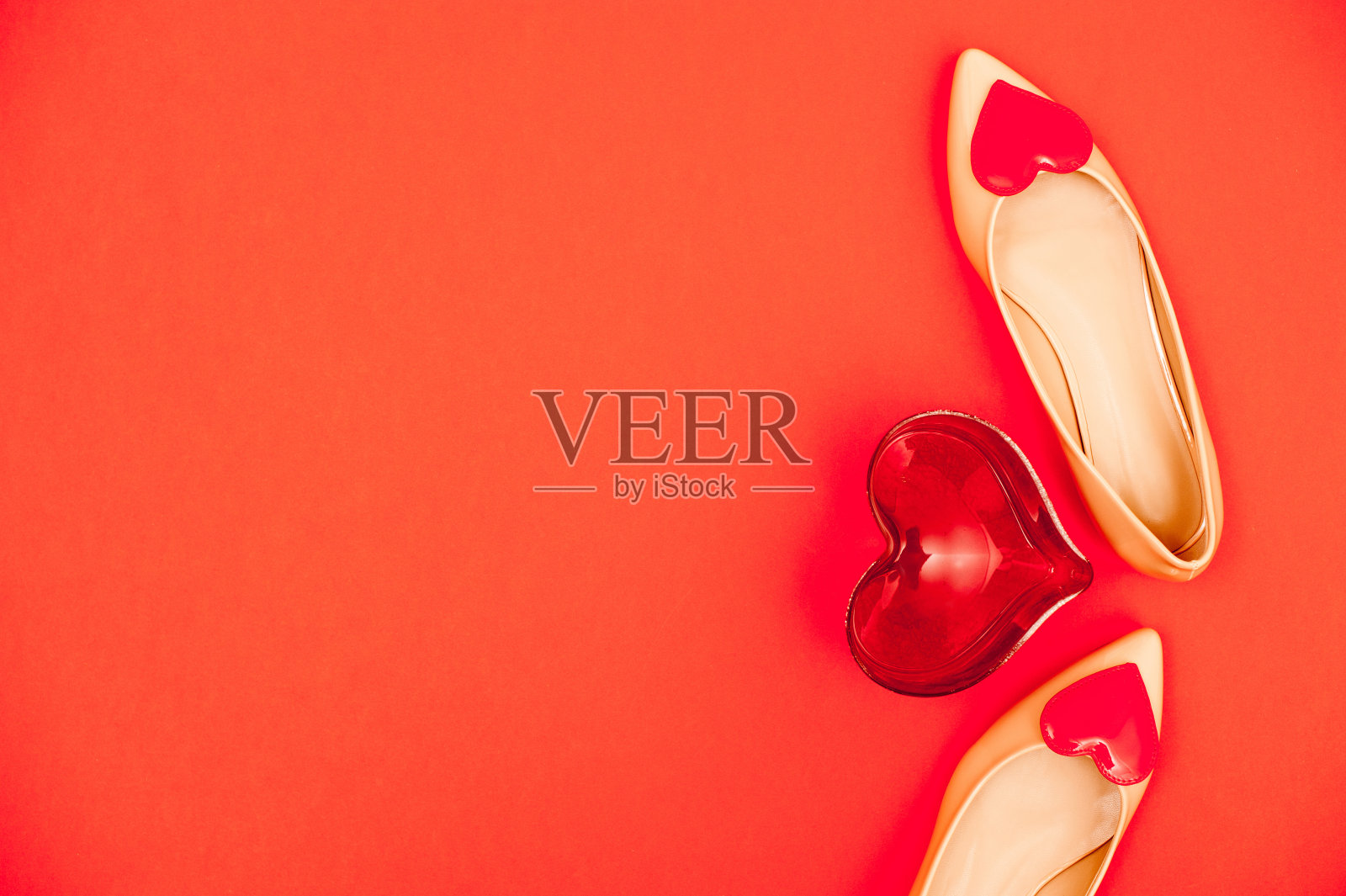 米色鞋子与红色的心为爱的一天在橙色的背景照片摄影图片