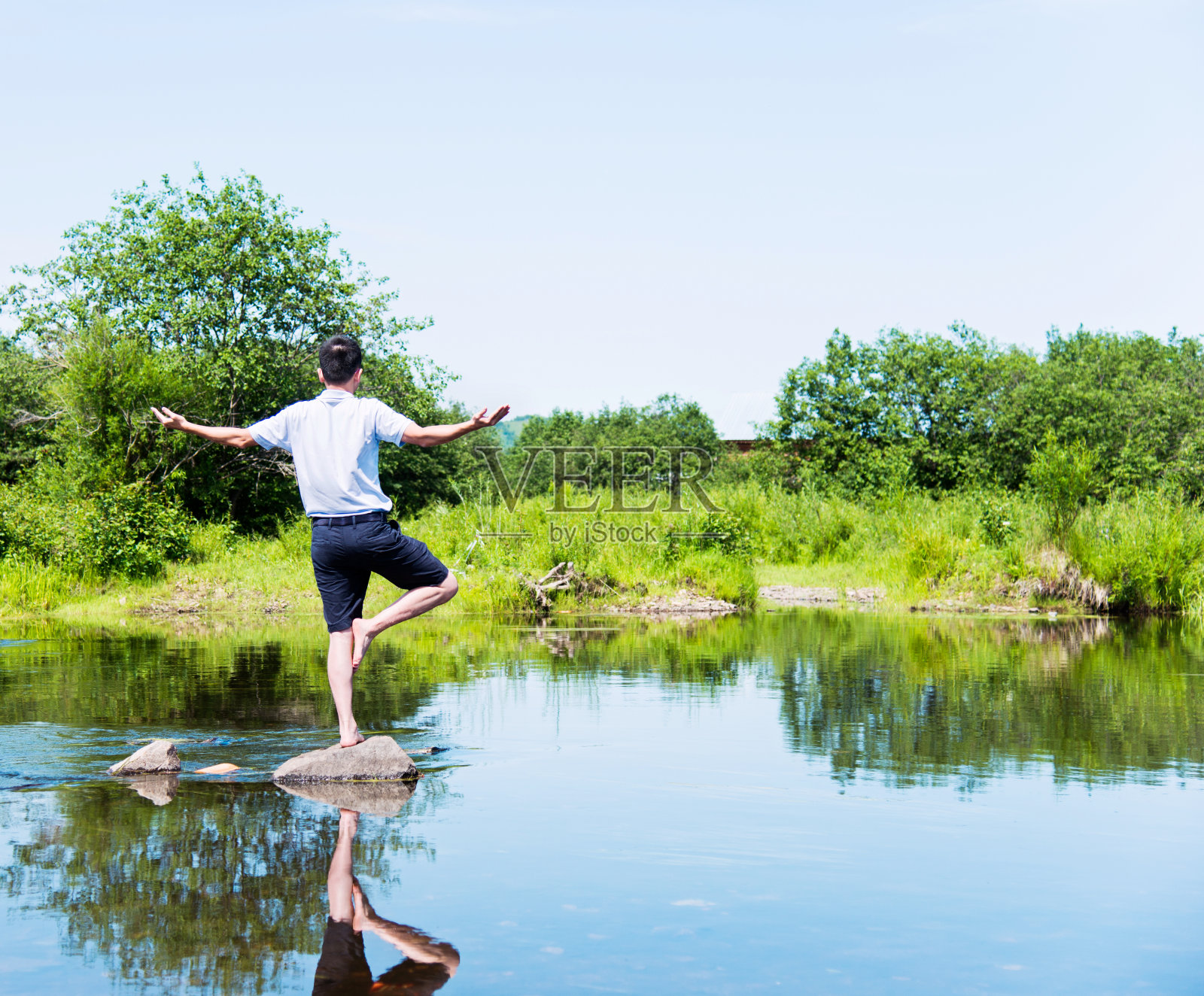 树上的人在岩石上做瑜伽照片摄影图片