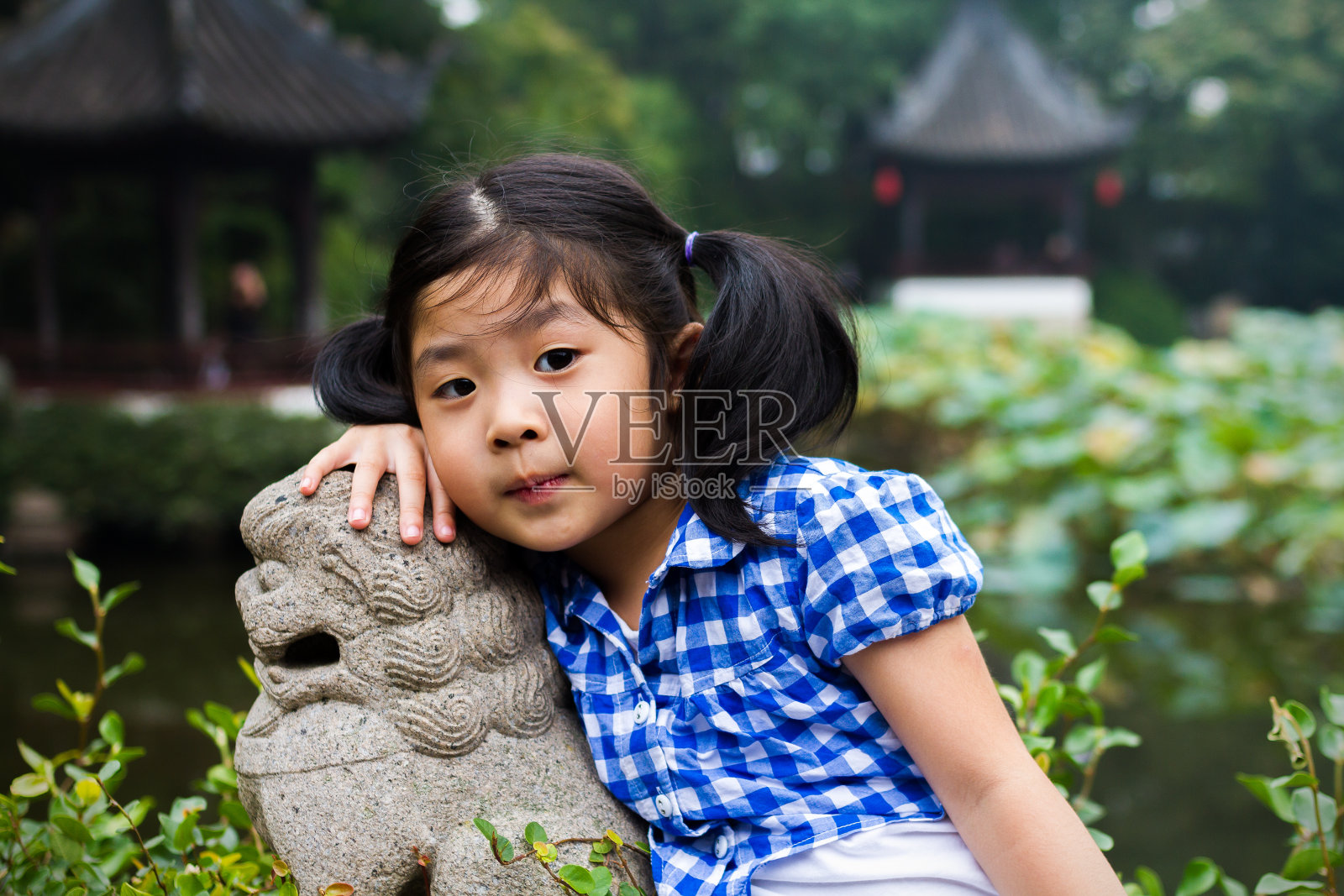 快乐的亚洲女孩在公园里做可爱的姿势照片摄影图片