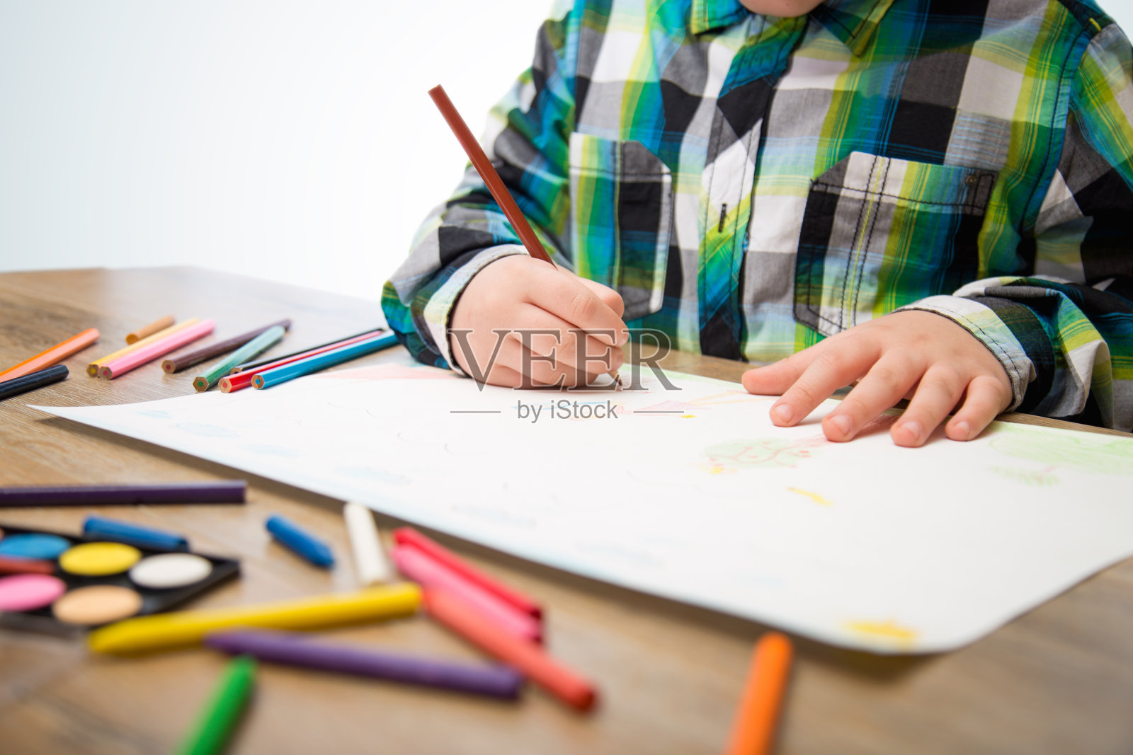 小男孩在白纸上画画照片摄影图片