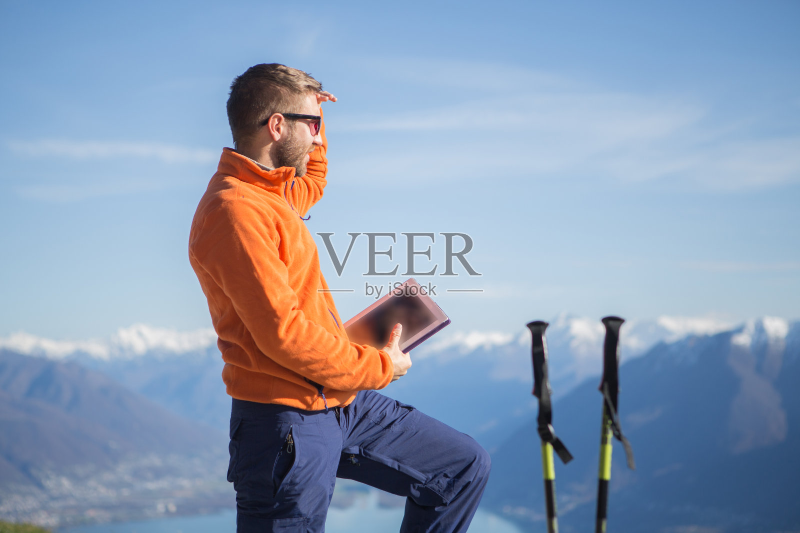 在山顶使用数位板徒步旅行的游客照片摄影图片